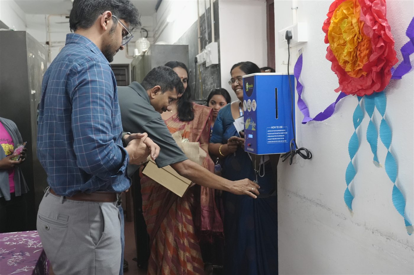 Handing over an ink dispenser at a school